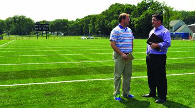 Almont's new gridiron: Interim Parks and Recreation Commissioner Chris Cook, left, and Ryan Woods, director of External Affairs for the department, are shown on the new football field at Almont Park. The Mattapan Patriots take the field on Friday. Photo by Bill Forry